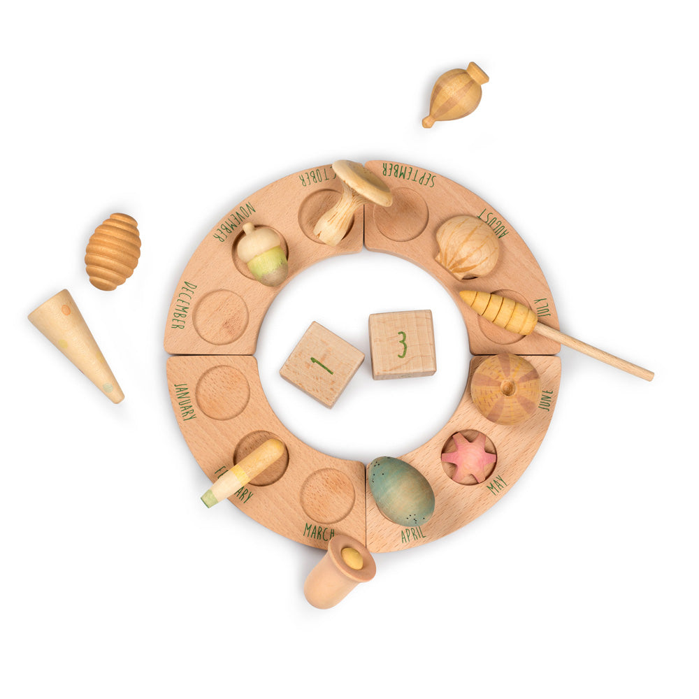 Grapat plastic-free wooden wonders toy pieces laid out on a perpetual calendar ring on a white background