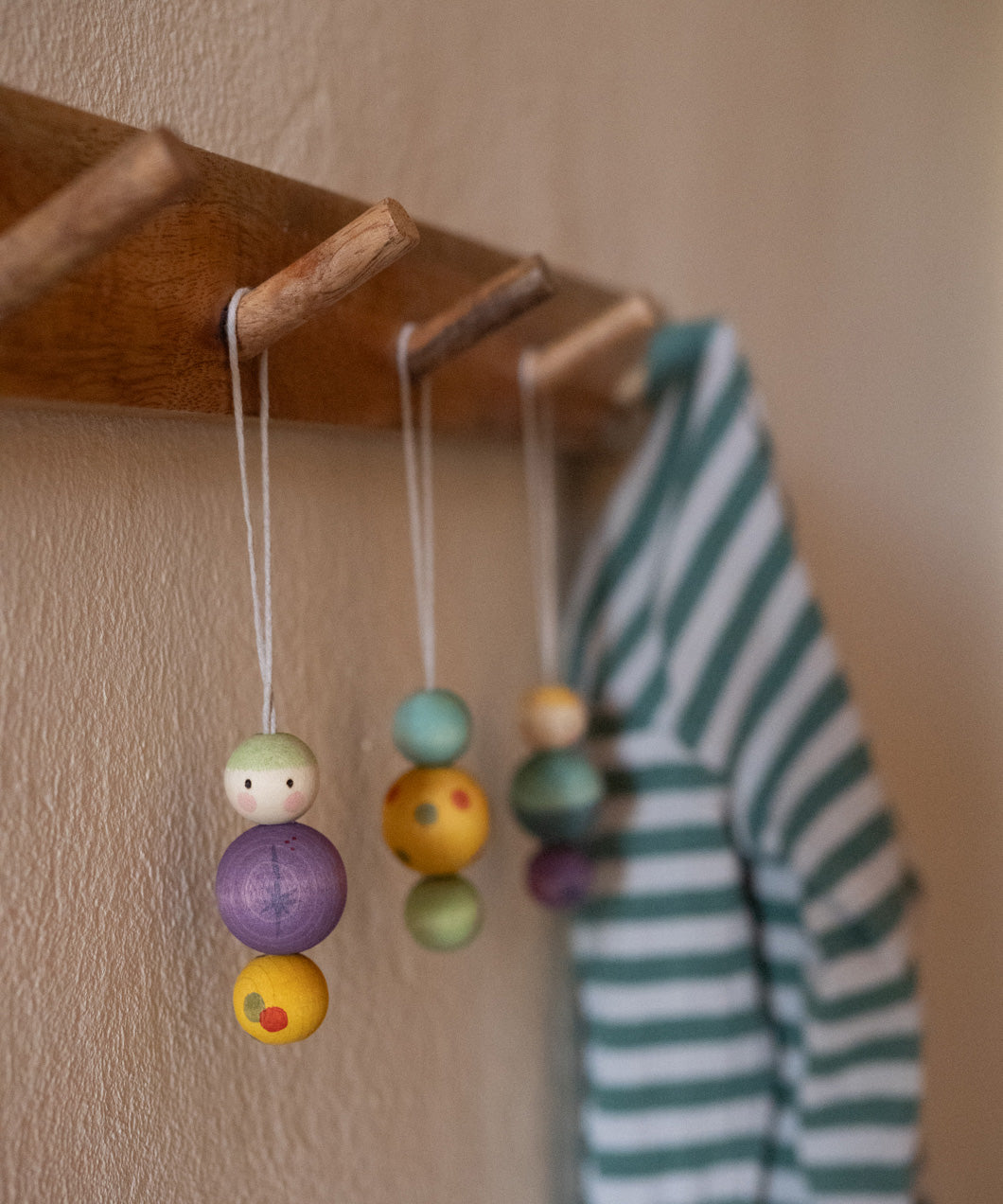 A wooden snow buddy wooden Grapat decoration hanging on a wooden hook.