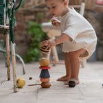 A child playing with the Grapat serendipity stacking set outside on the floor