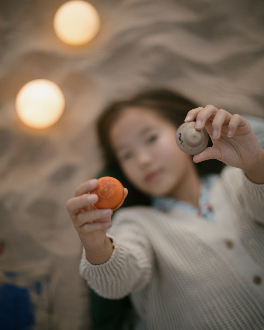 a child is gazing at one of the small planets