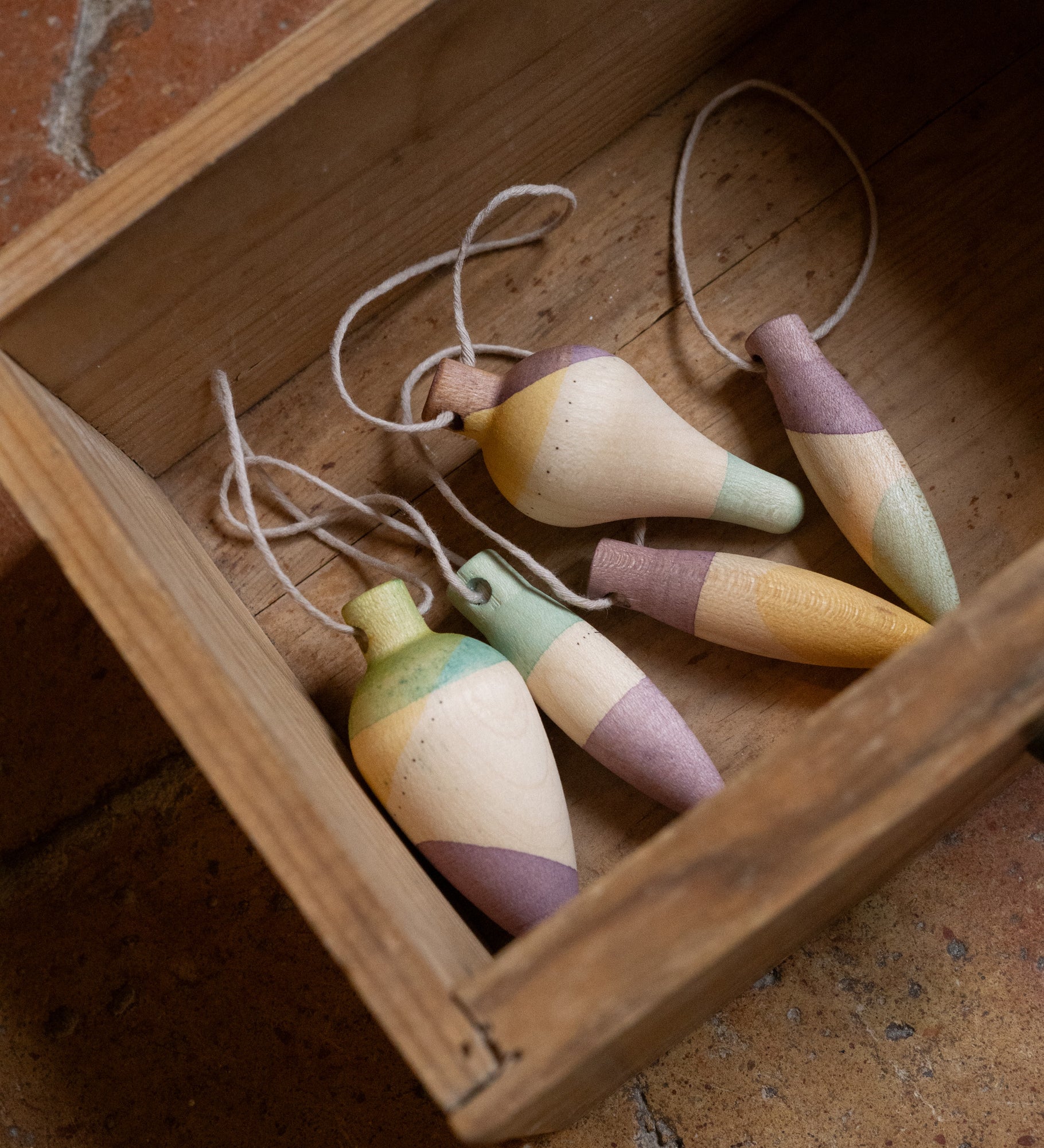 Multicoloured wooden Grapat twinkle decorations in a wooden box