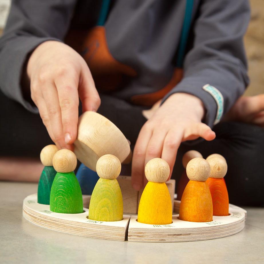 Grapat English Perpetual Calendar displaying the 12 nin peg dolls in colours representing the months of the year according to Waldorf teachings. The display ring has each month written in English around the edge and two cubes in the centre to mark the day