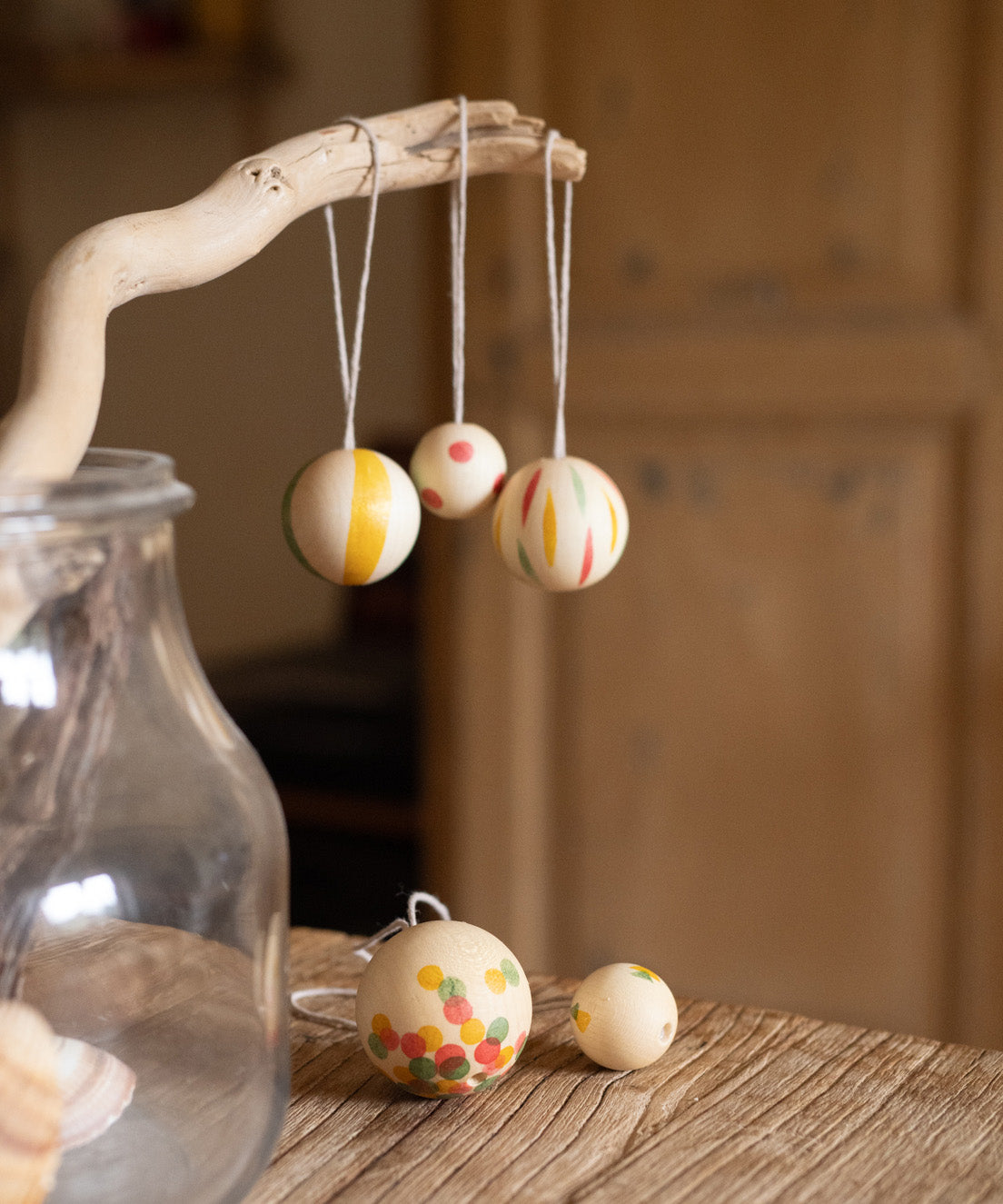 multicoloured patterned Grapat wooden balls hanging on a stick