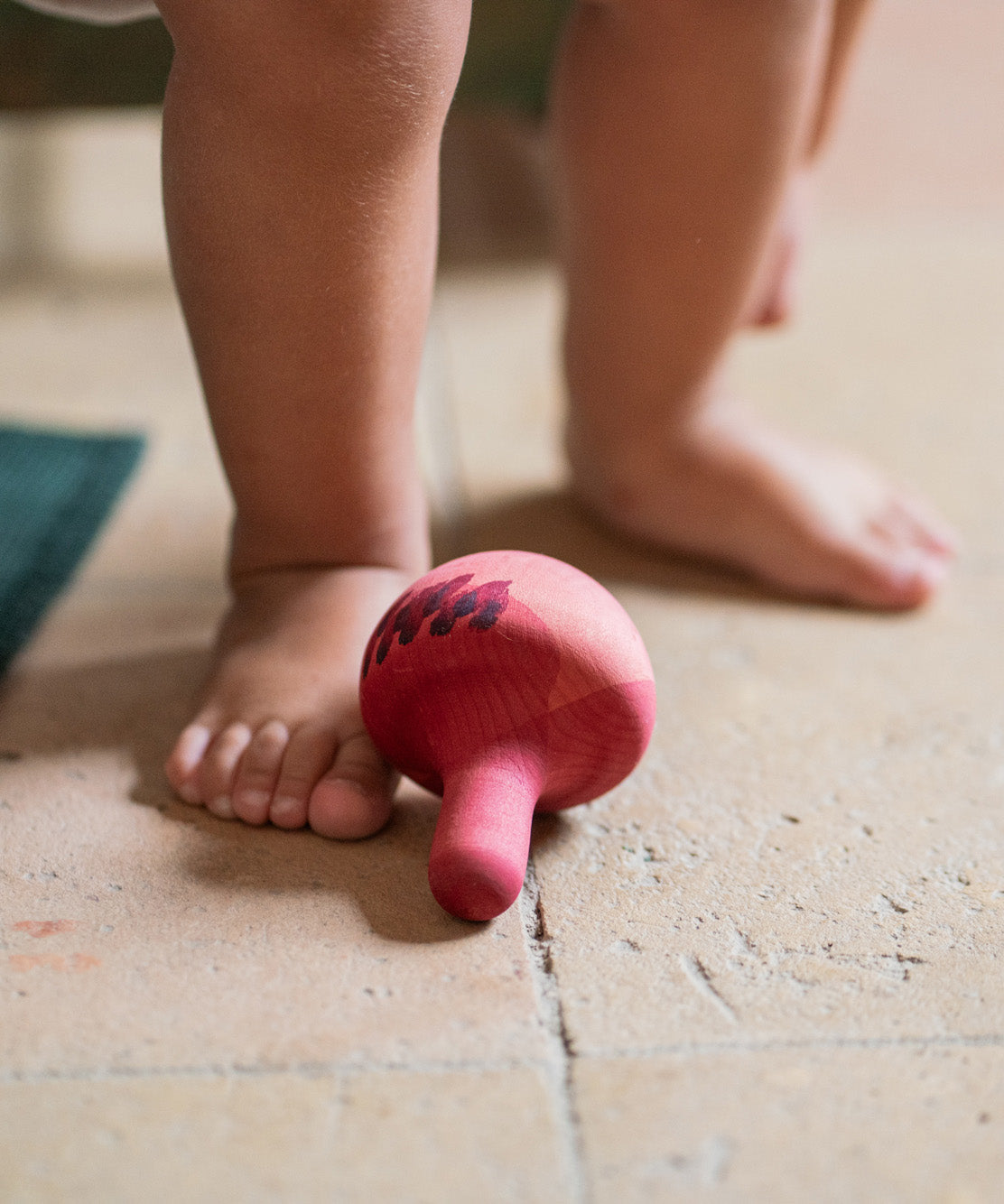 Grapat wooden pink chill bird on a floor next to feet