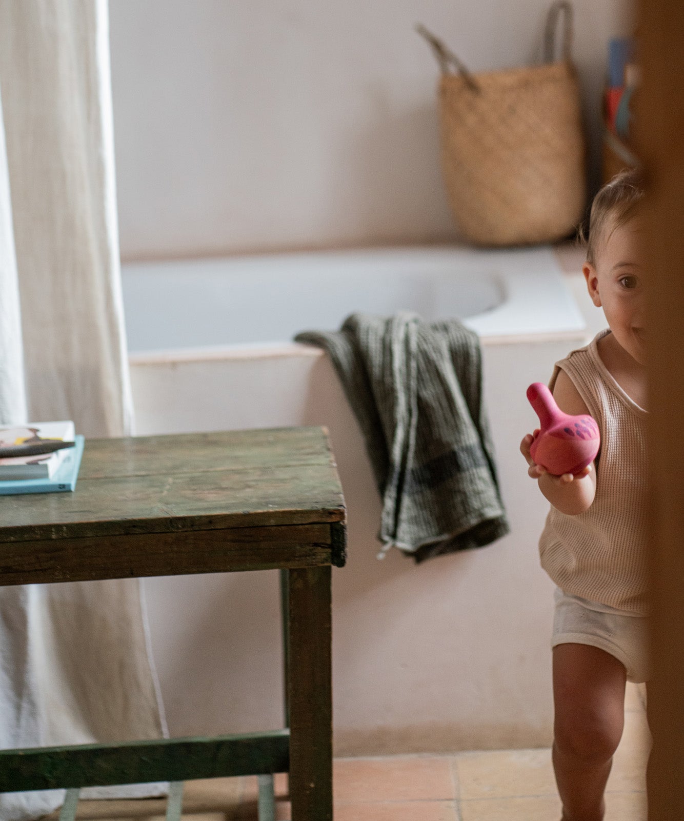 A child playing with the Grapat wooden pink chill bird next to a  table