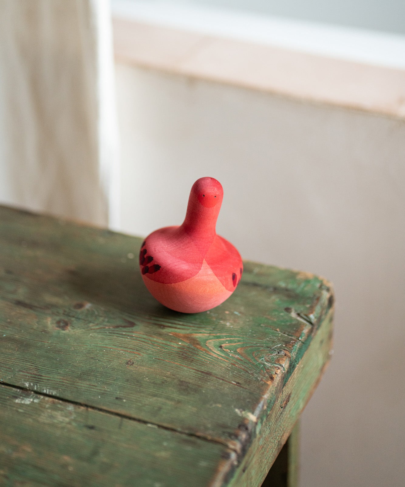 A Grapat wooden pink chill bird on a wooden table