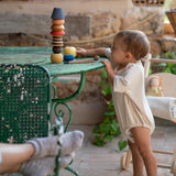 A child playing with the Grapat serendipity wooden stacking set on a table