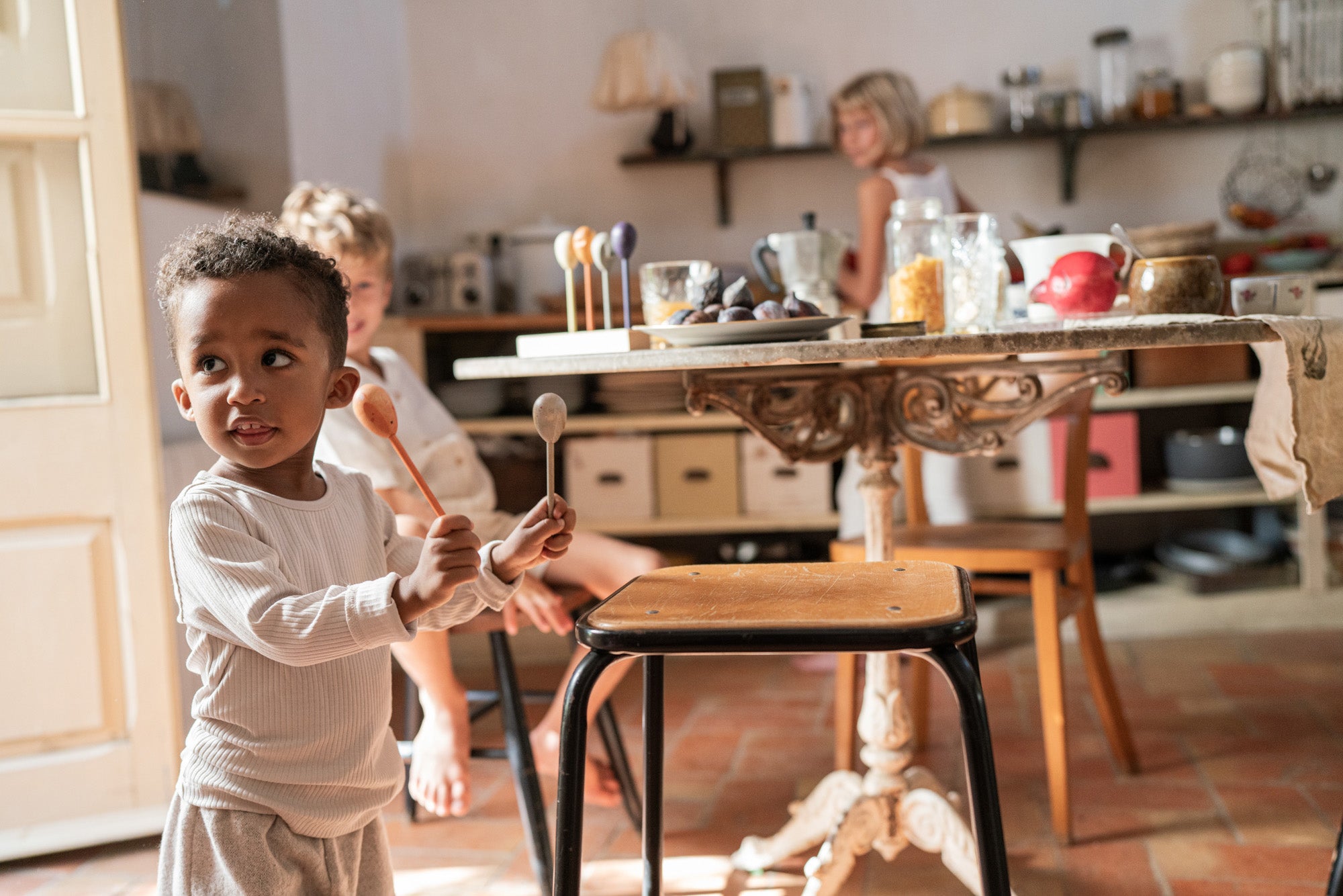 A child playing with the Grapat wooden twin soul puppets by a chair