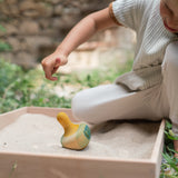 A child playing with the Grapat wooden yellow flowing bird outside 