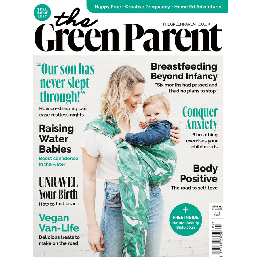 Green parent magazine cover featuring a mother using a sling to carry a young child and a father giving an older child a piggy back.