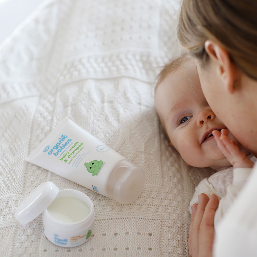 baby wash & shampoo from the Organic Babies Newborn Collection Gift Set pictured next to a baby