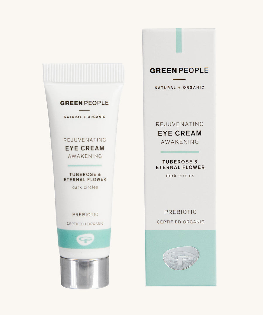 Green People Rejuvenating Eye Cream in a tube next to the cardboard packaging on a plain background. 