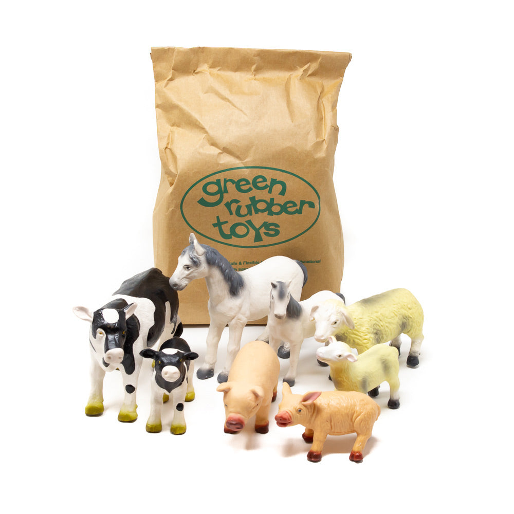 Green Rubber Toys biodegradable farm animal toys on a white background next to their recyclable paper bag packaging