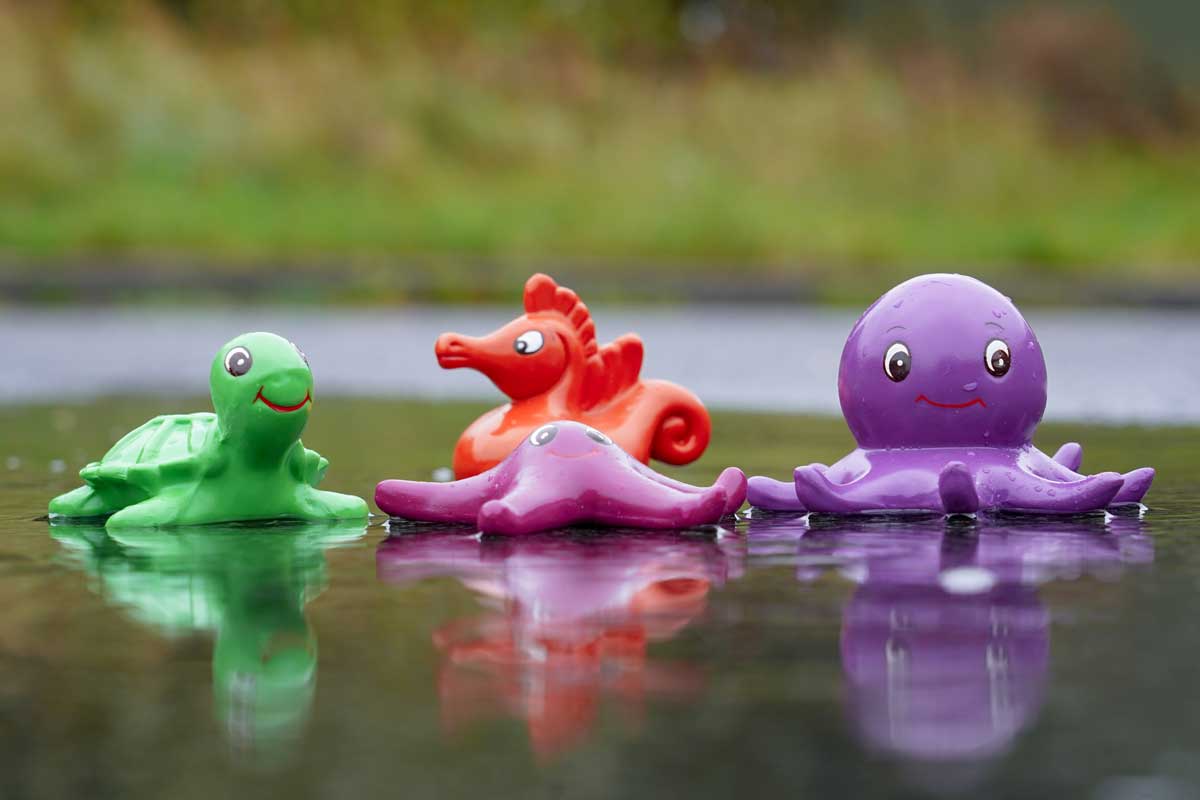 Green Rubber Toys Sea Friends Bath Toy Set pictured in a puddle