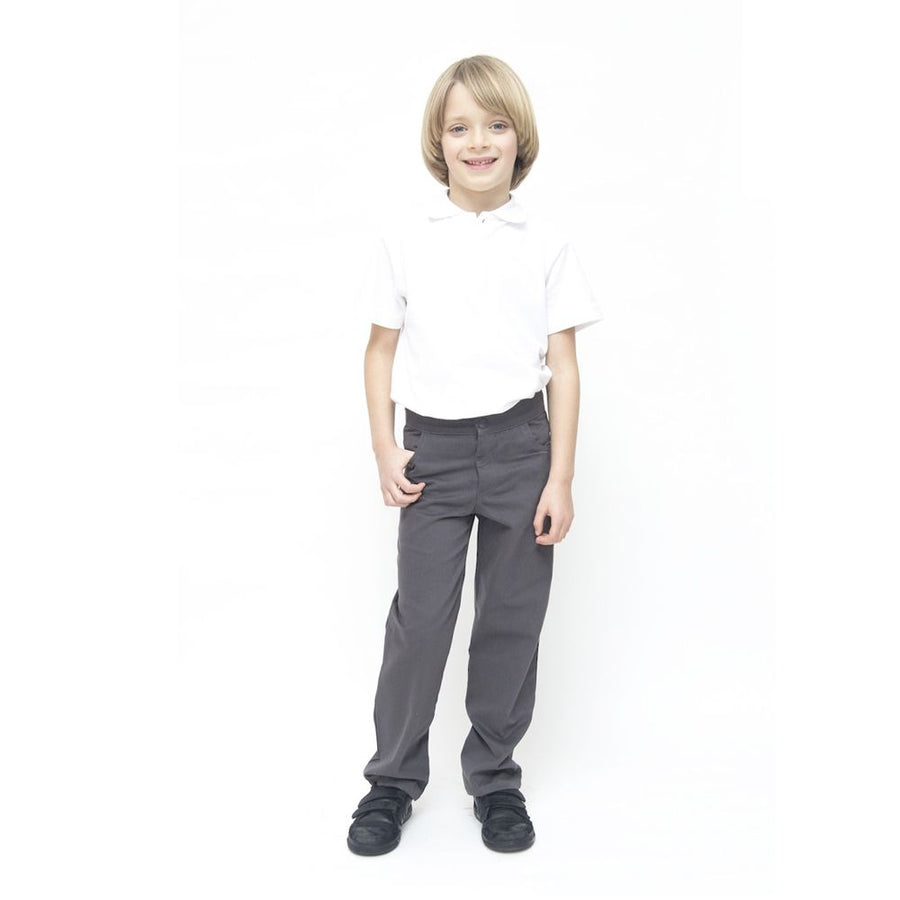 A child wearing Eco Outfitters GOTS organic cotton school uniform trousers - boys slim fit in grey, with a white polo shirt and black shoes, smiling with right thumb in pocket. White background
