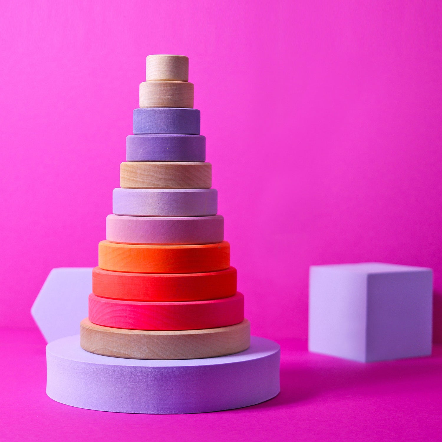 Grimm's Conical Stacking Tower - Neon Pink - A child plays alone with the stacking toy.