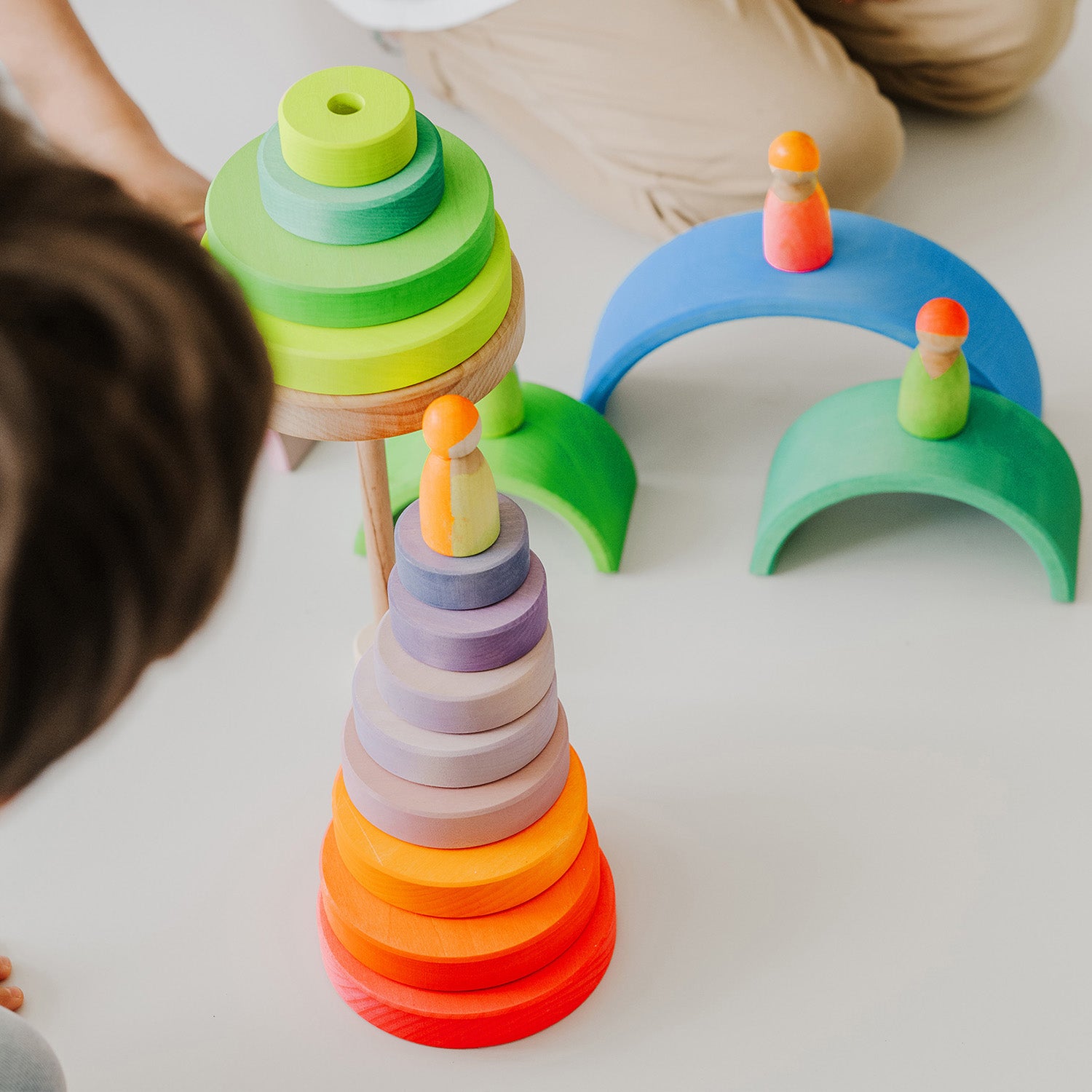 Grimm's Conical Stacking Tower - Neon Pink - Two children play with several sets of Grimm's Rainbows