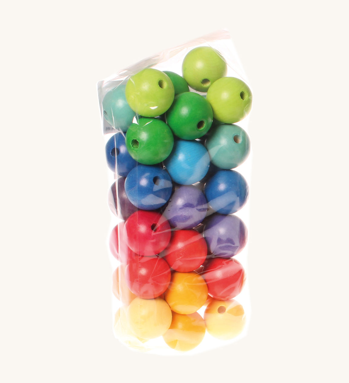 Rainbow coloured wooden Grimms beads in bag on a cream background.