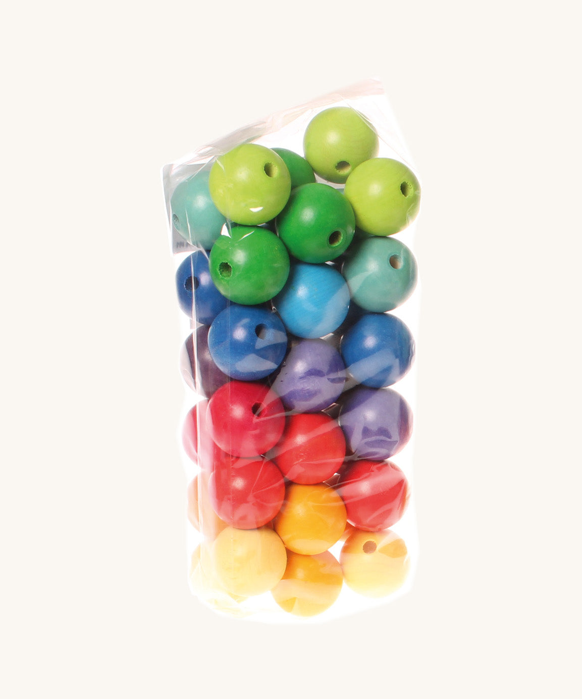 Rainbow coloured wooden Grimms beads in bag on a cream background.