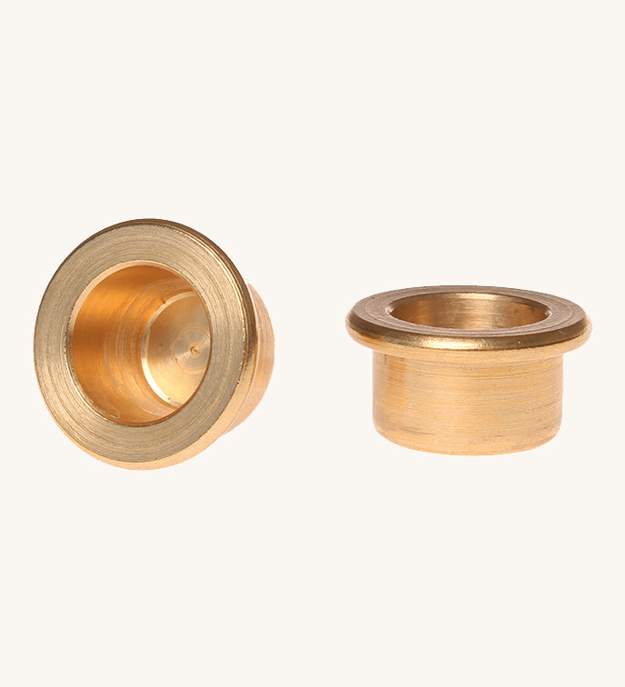 Grimm's brass candle holders to fit celebration rings on a plain background. 