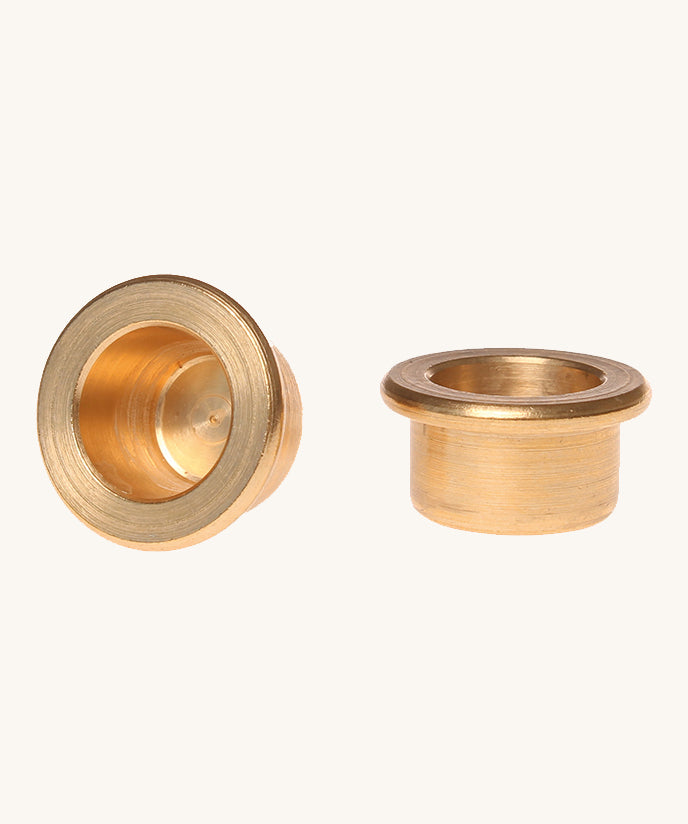 Grimm's brass candle holders to fit celebration rings on a plain background. 