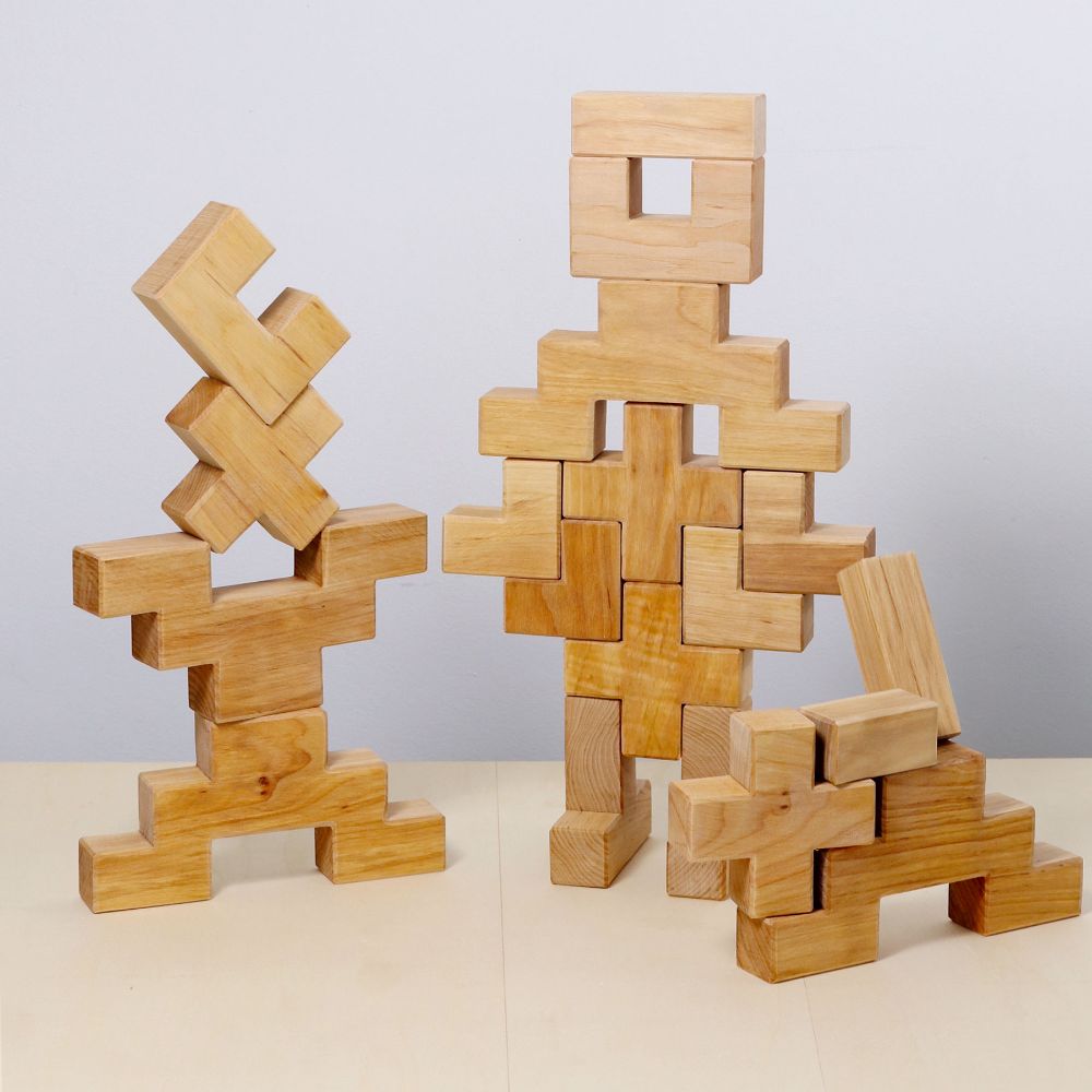 Pieces from the Grimm's Natural Wooden Stairway Building Set stacked up in different shapes. 