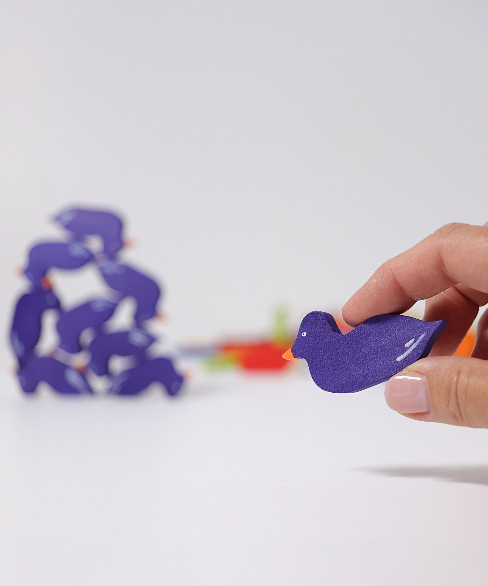 A wooden duck figure from the Grimm's Figures For Counting & Story Telling set in an adult's hand.