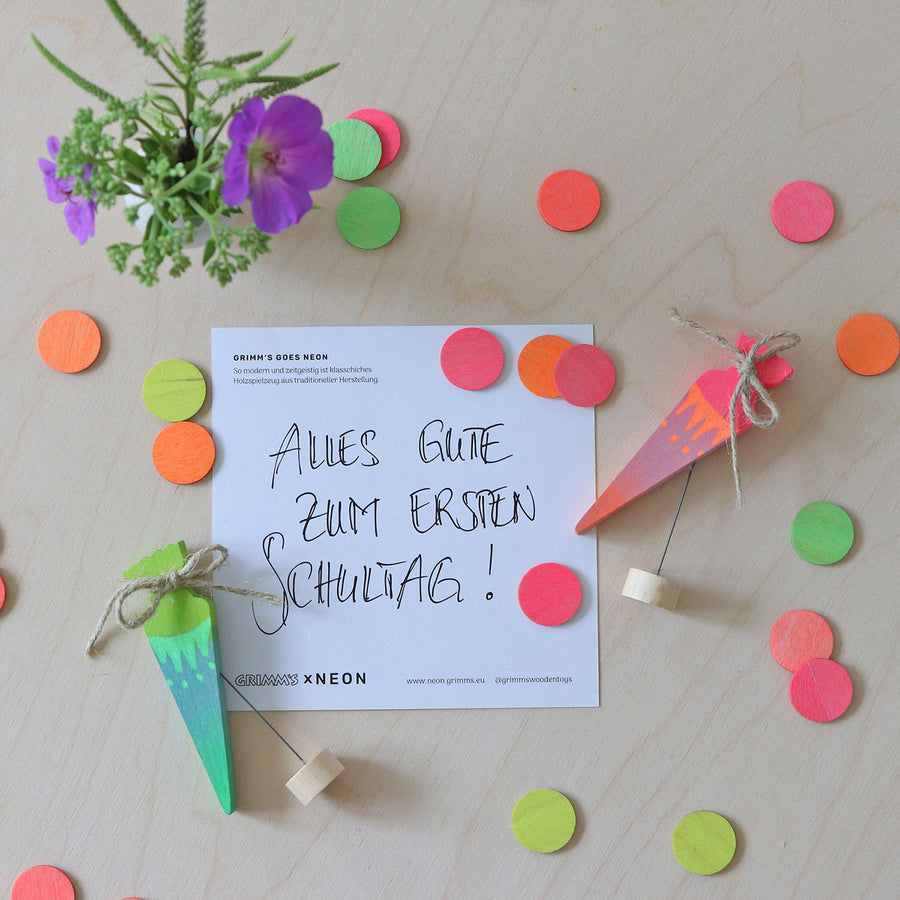 Grimm's Neon Celebration Confetti Dots. The dots surround a celebration ring on a wooden table.