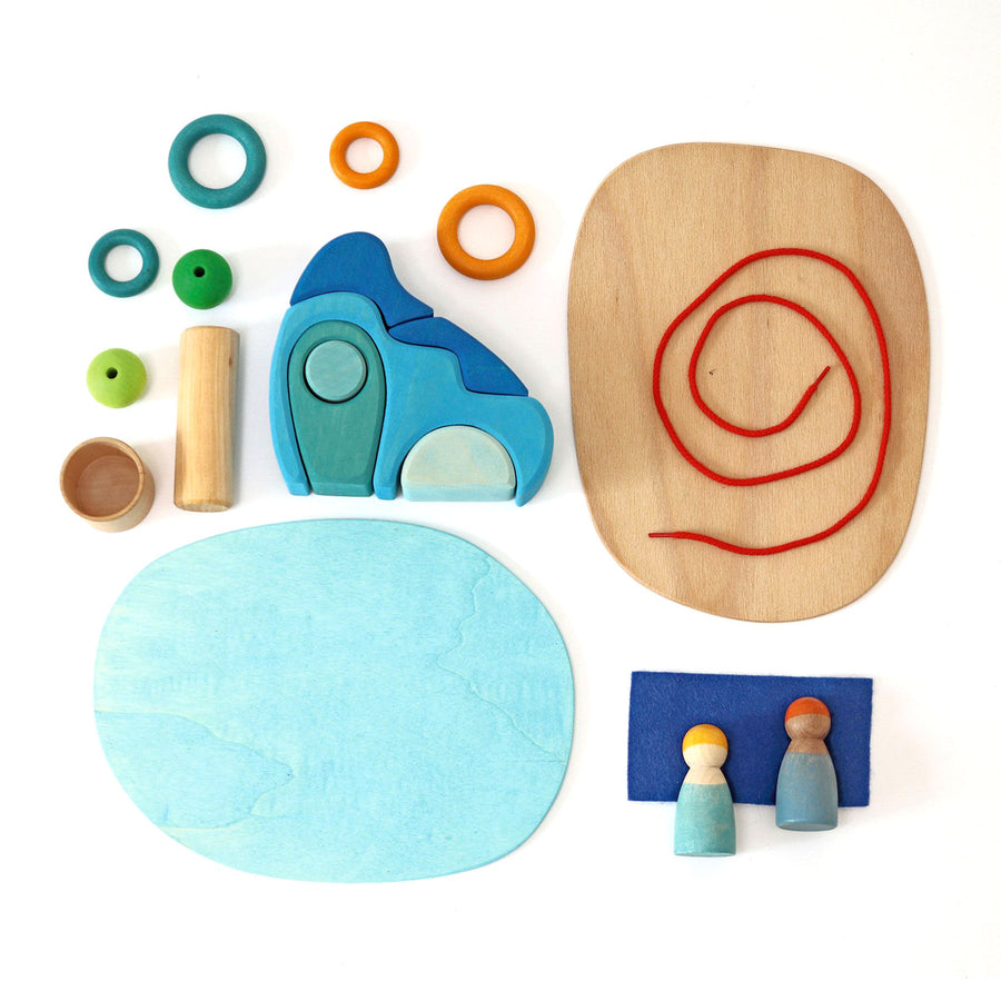 Pieces of the Grimm's plastic-free small world play: by the water set laid out on a white background