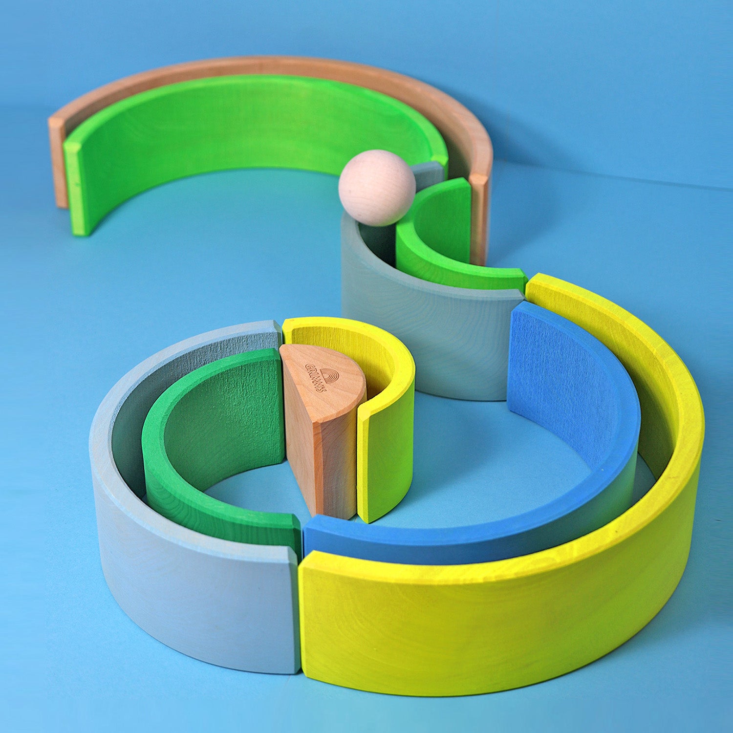 Grimm's 10-Piece Rainbow - Neon Pink. A child plays in his house with several sets of Grimm's Rainbows and Neon friends.