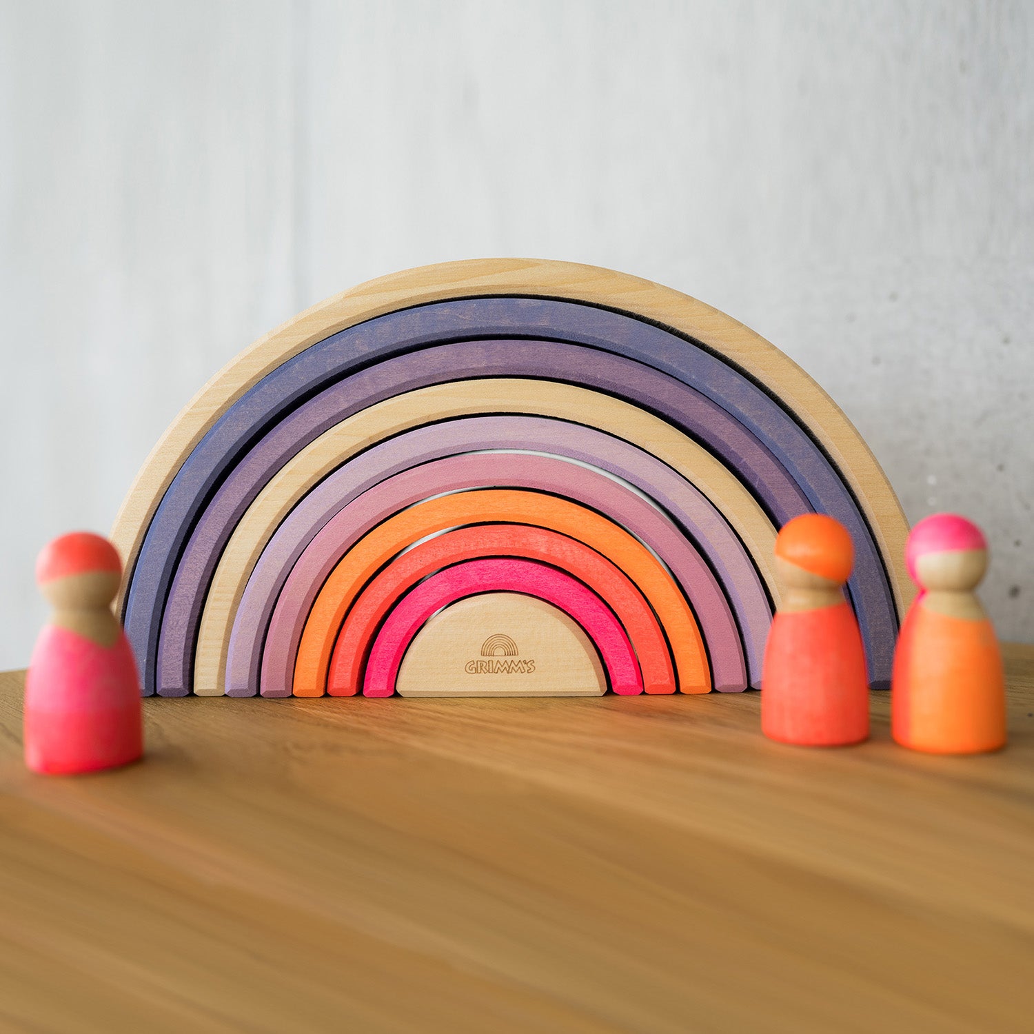 Grimm's 10-Piece Rainbow - Neon Pink. A child plays with several sets of Grimm's Rainbows