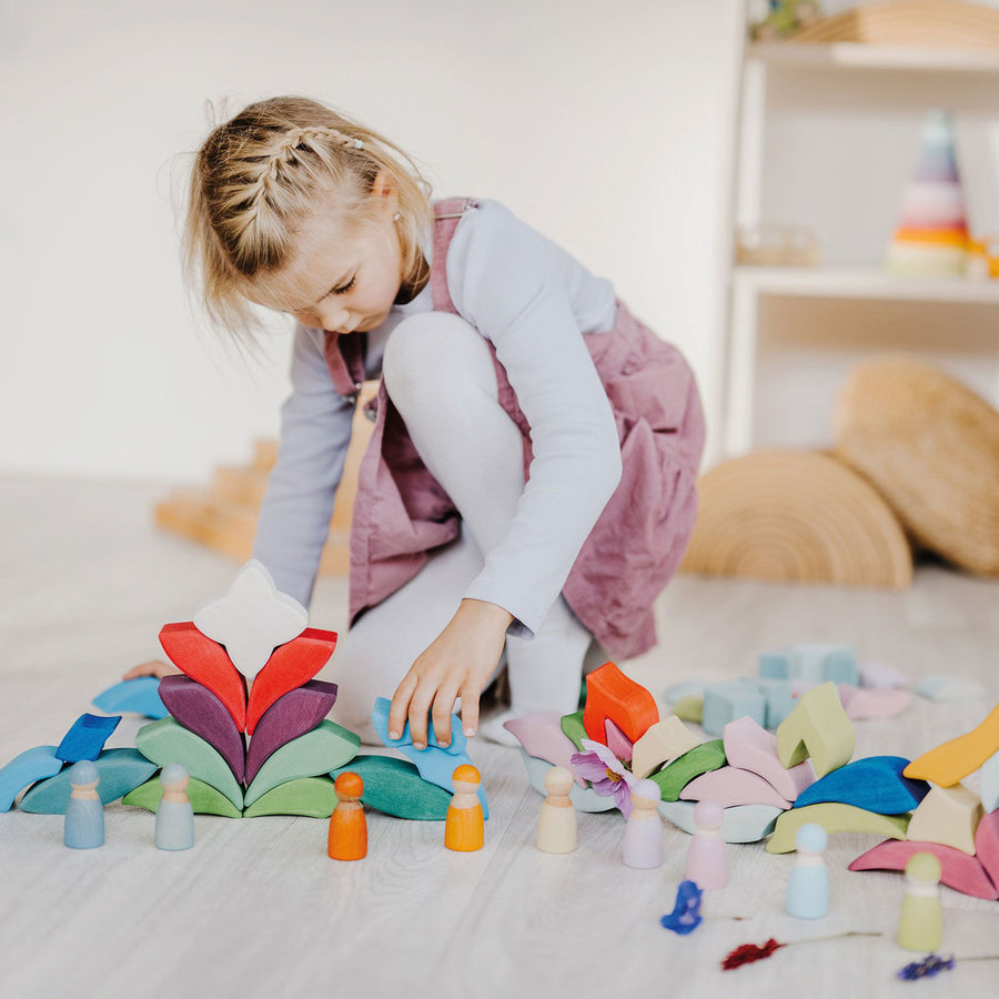 2 people's hands holding up the Grimm's Lara toy blocks set