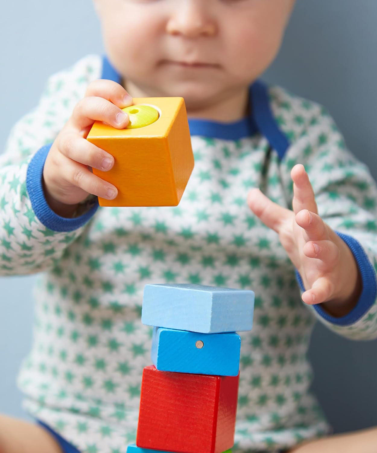 A close up of the orange wooden cube from the Haba blocks with sounds set.