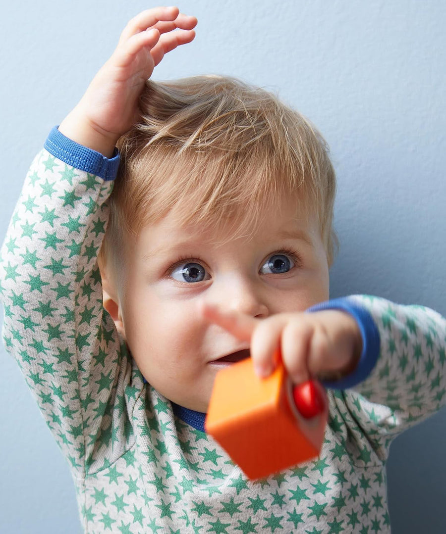 A child playing with the orange cube from the Haba blocks with sounds set