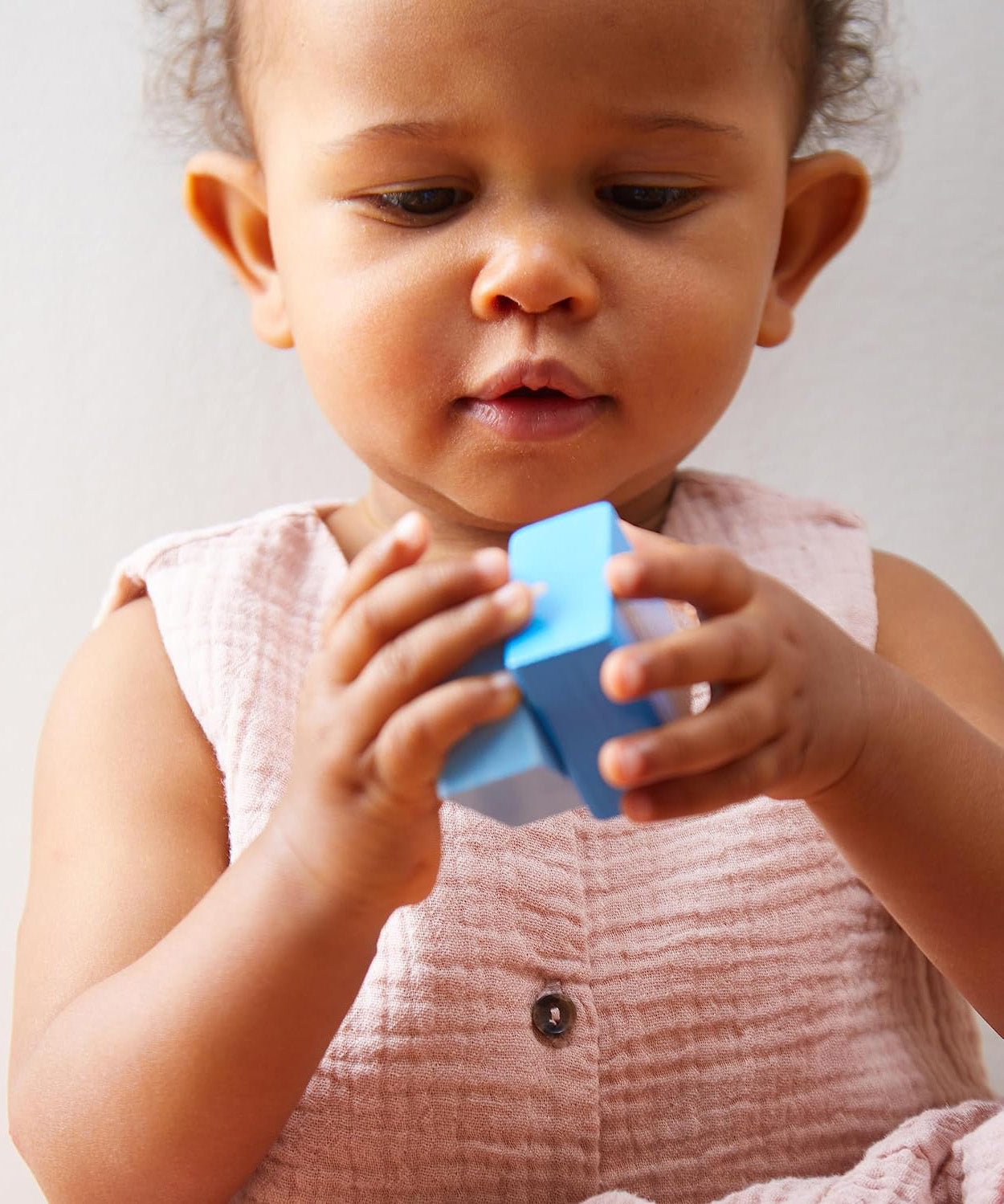 A child playing with the blue cube from the Haba blocks with sounds set