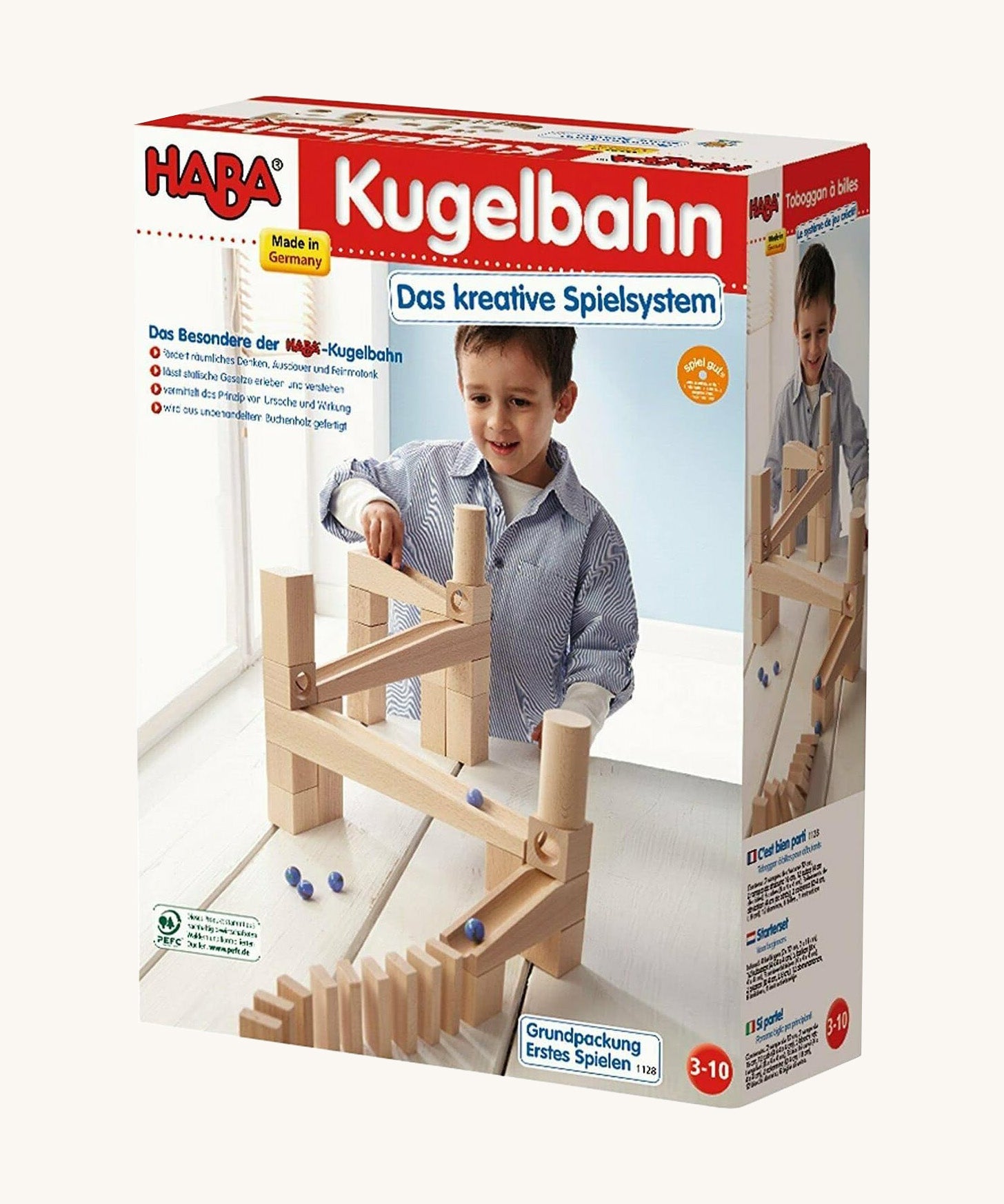 A cardboard box with a picture of a marble run for the Haba my first playing blocks on a cream background.