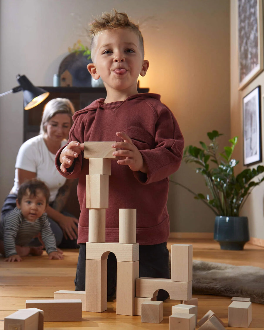 A child placing the HABA Large blocks on top of each other to create a tower