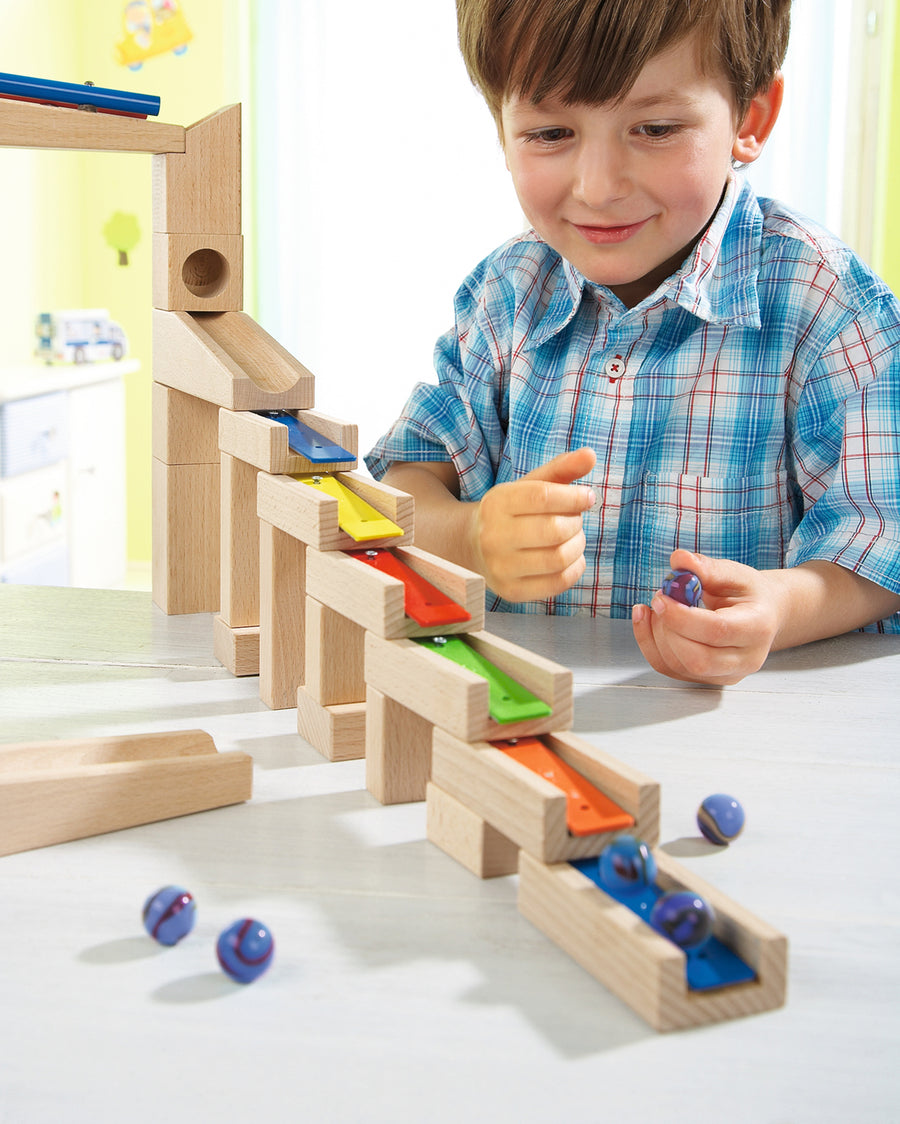 A child happily making music with the HABA Wooden Melodious Marble Run