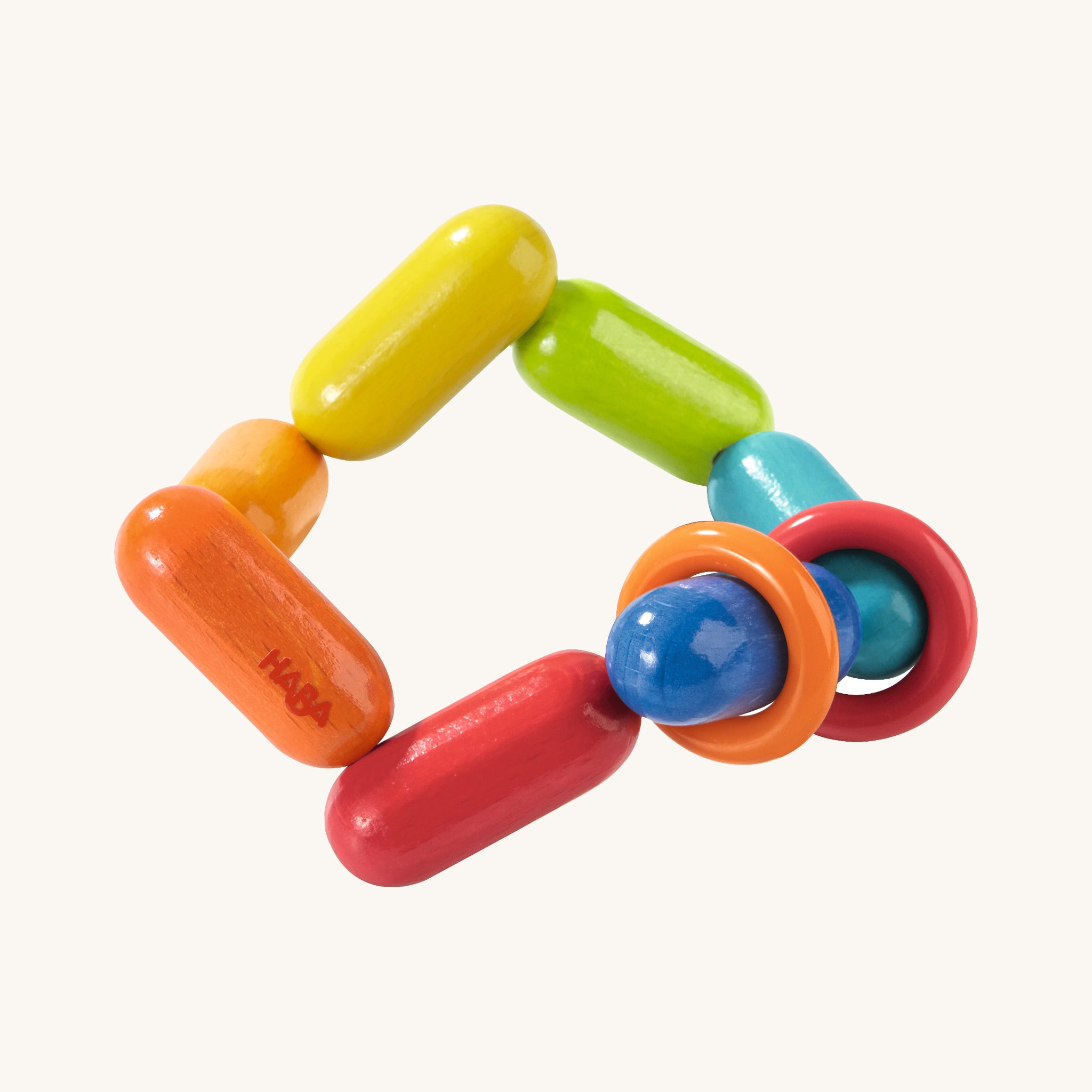 HABA Wooden Baby Clutching and Teething Toy - Dilly Dally. A colourful and bright clutching and teething baby toy with long rainbow beads and an orange and red ring that can move along the beads, on a cream background