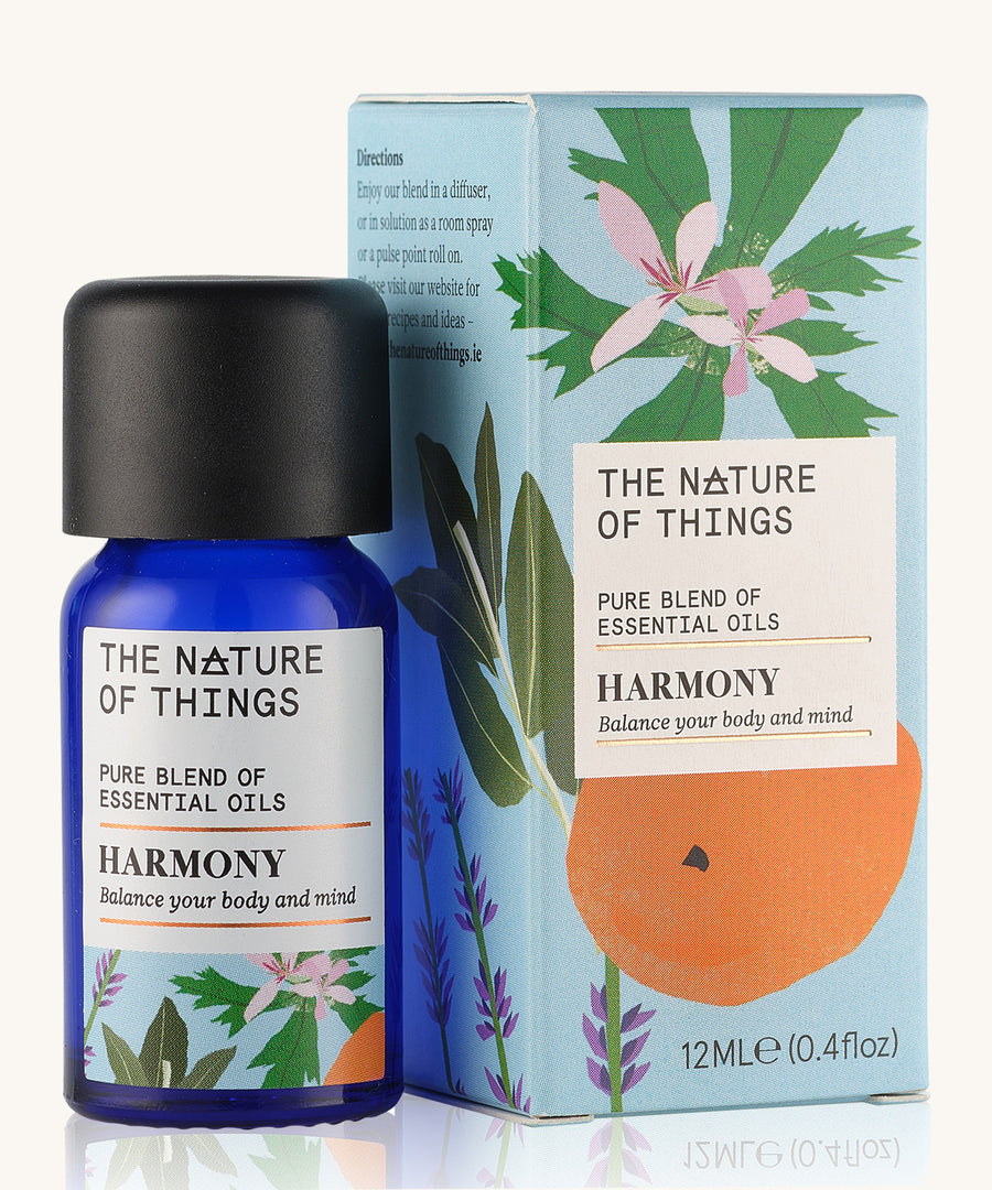 Harmony pure essential oil blend in a blue glass bottle in front of a decorative blue cardboard box.