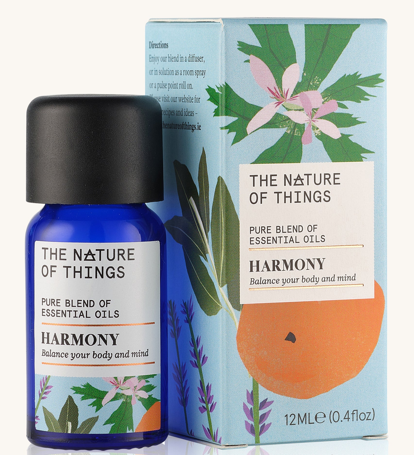 Harmony pure essential oil blend in a blue glass bottle in front of a decorative blue cardboard box.