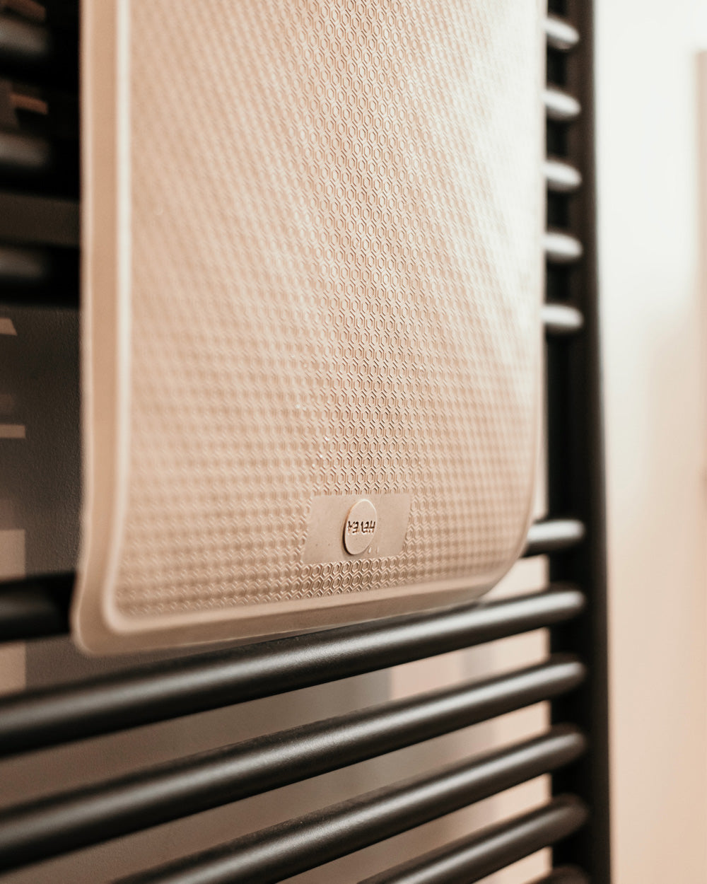 Close up of a Hevea natural rubber bath mat hanging over a towel rail