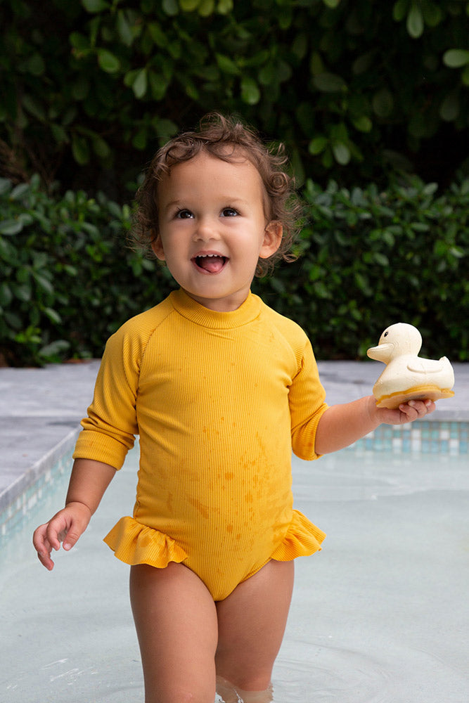 Hevea sand rubber duck held by child near swimming pool