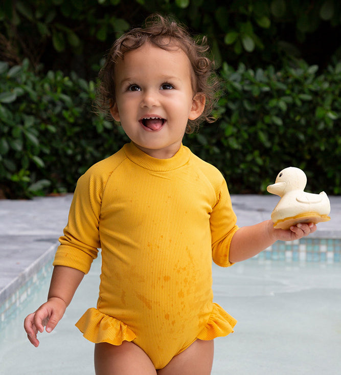 Hevea sand rubber duck held by child near swimming pool