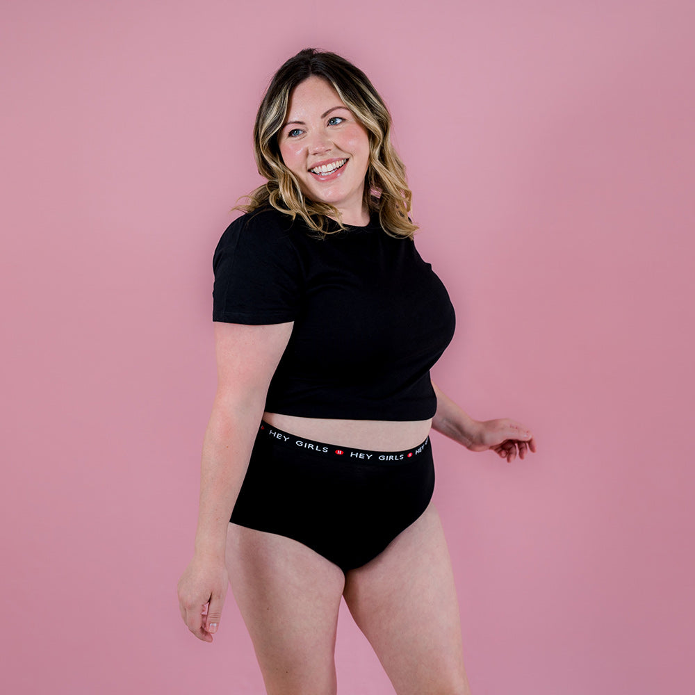 Hey Girls Super Soft Black Cherry Reusable Period Pants worn by a person wearing a black top against a pink background