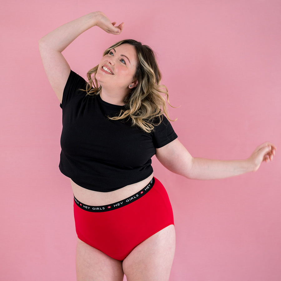 Hey Girls Super Soft Red Cherry Period Pants worn by a dancing person with a black top on a pink background