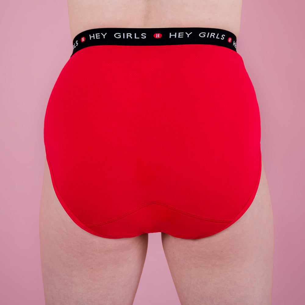 Hey Girls Super Soft Red Cherry Period Pants worn by a person on a pink background