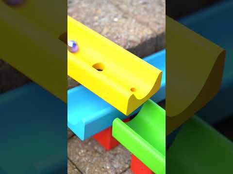 Close up of a hand rolling a Grimm's wooden ball down the Erzi water and marble run toy set