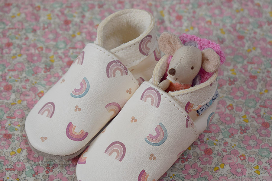 Inch Blue Leather Baby Shoes - Rainbow Love with a little toy mouse and crochet cushion inside on a floral sufrace