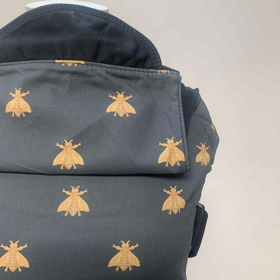 Close up of the Integra navy bee cotton baby carrier on a grey background